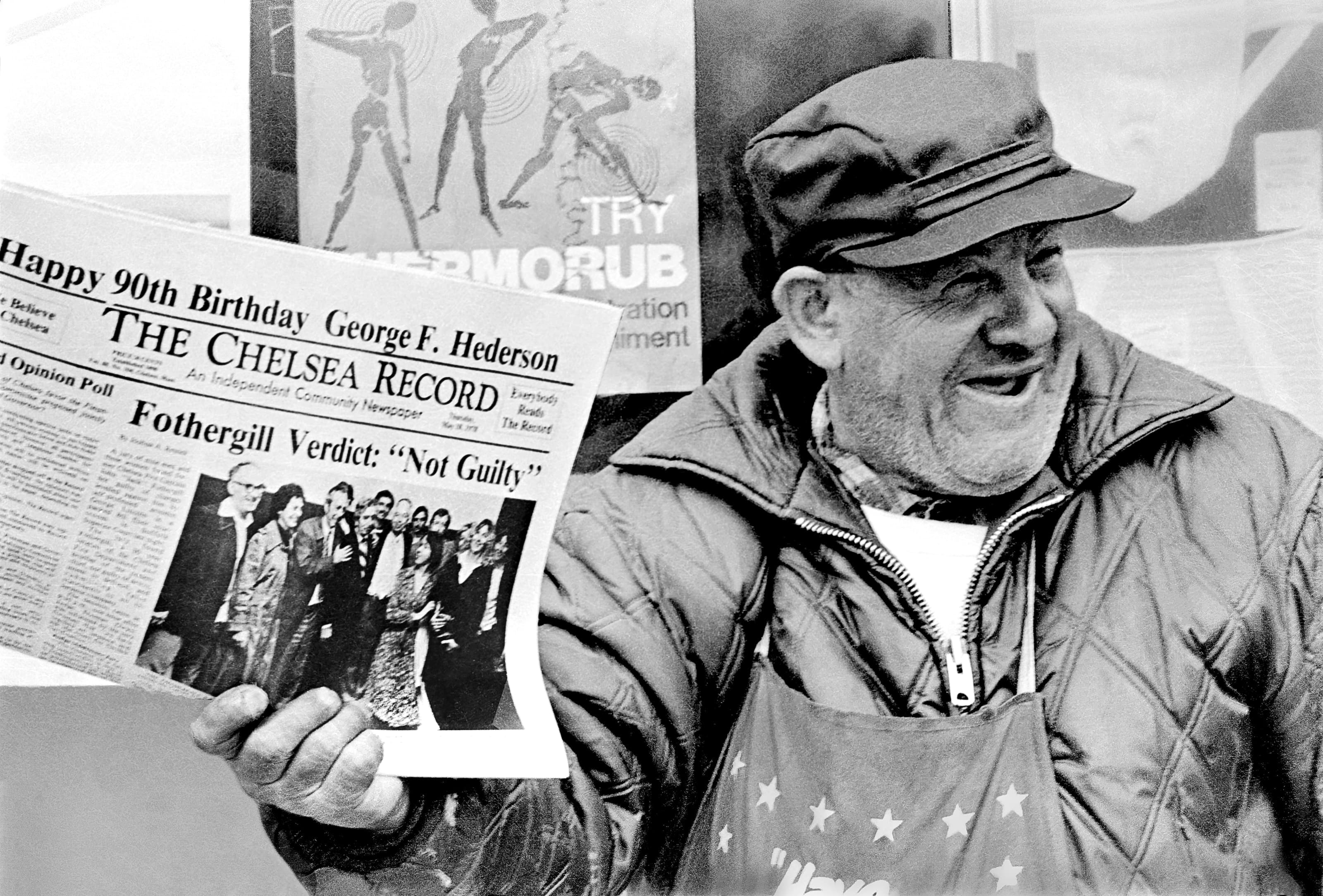 Black-and-white portrait of Al Goldman smiling while holding an issue of the Chelsea Record.