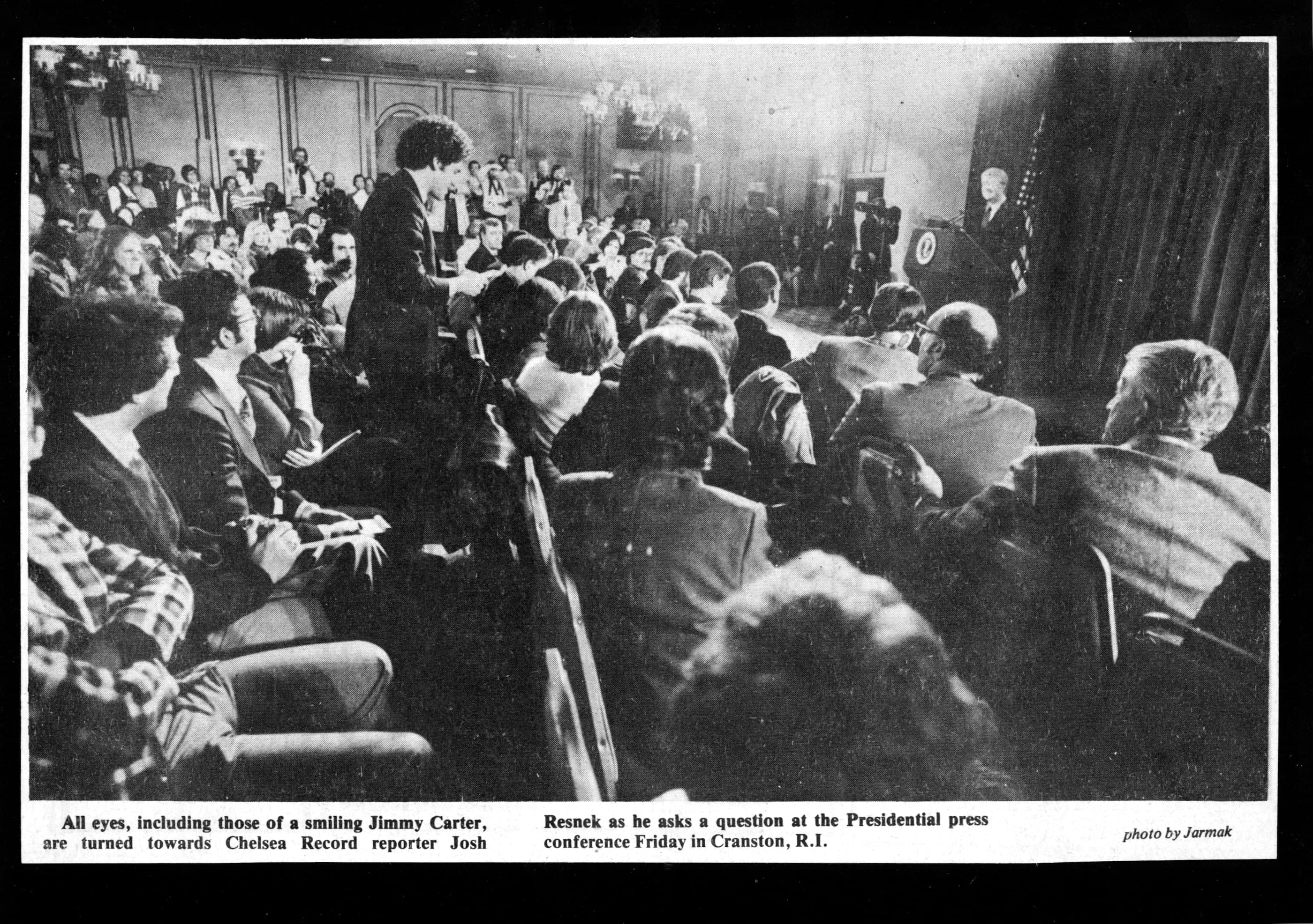 Chelsea Record photograph credited to Jarmak, showing Joshua Resnek asking a question at a presidential press conference in Cranston, Rhode Island.