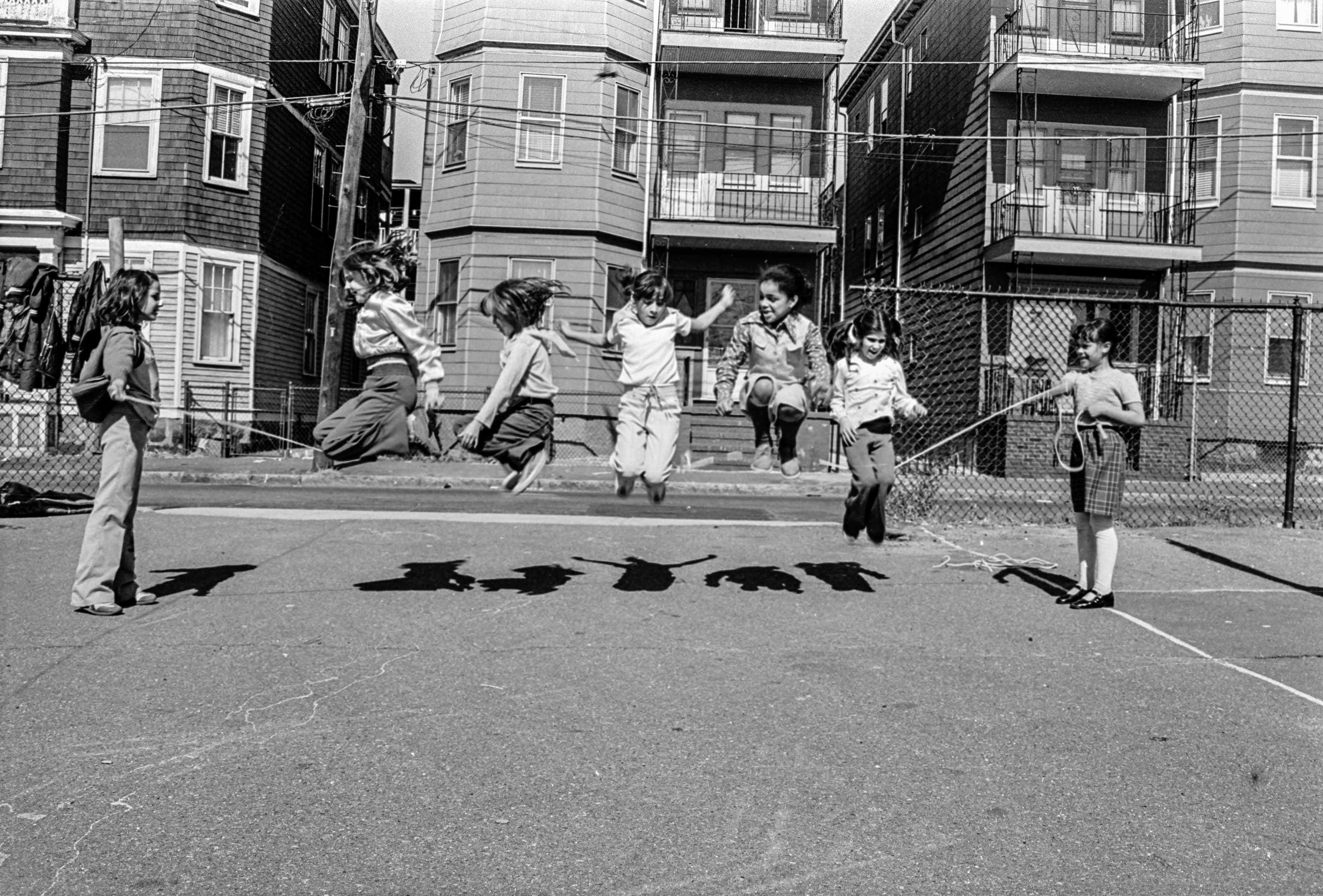Black-and-white photograph of children jumping rope in Quigley Park in Chelsea.