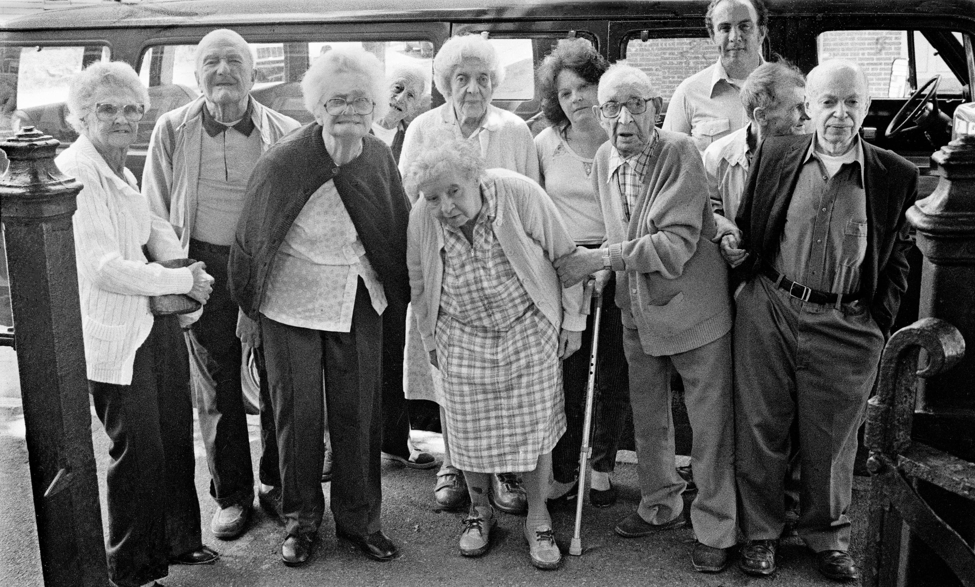 Black-and-white group portrait of older adults gathered closely together.