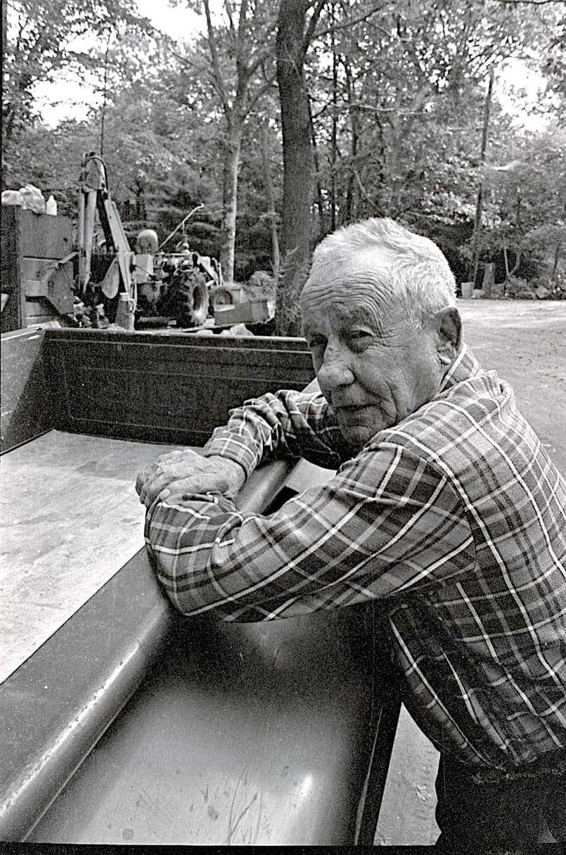 Black-and-white portrait of Tutt Ahonen leaning on the side of a truck in Lanesville.